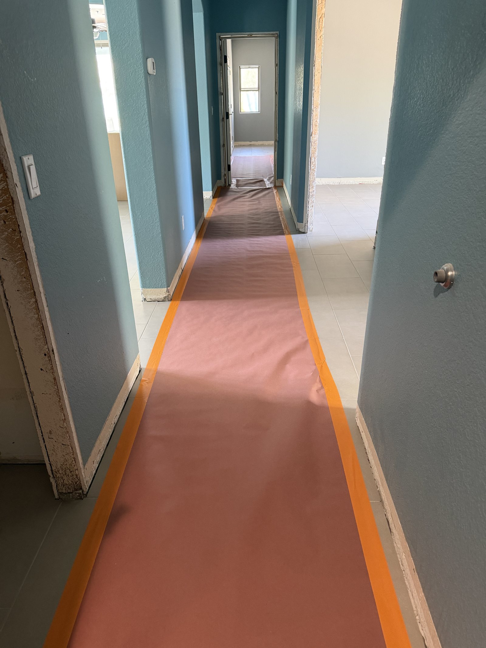 Protective floor paper running through the hallway during whole-home flooring installation, Fountain Hills remodel