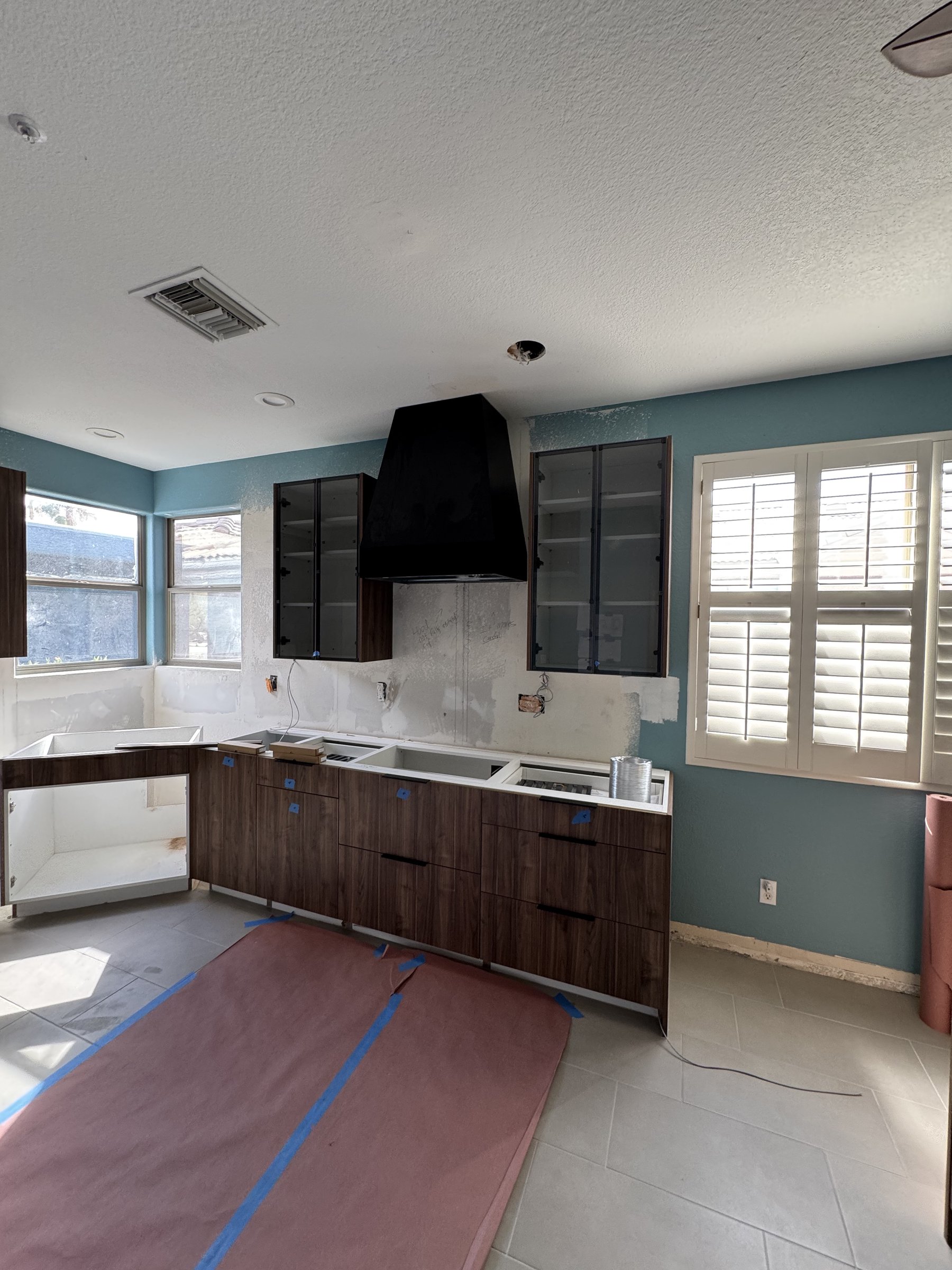 New walnut cabinetry and range hood installed before backsplash and paint, Fountain Hills remodel