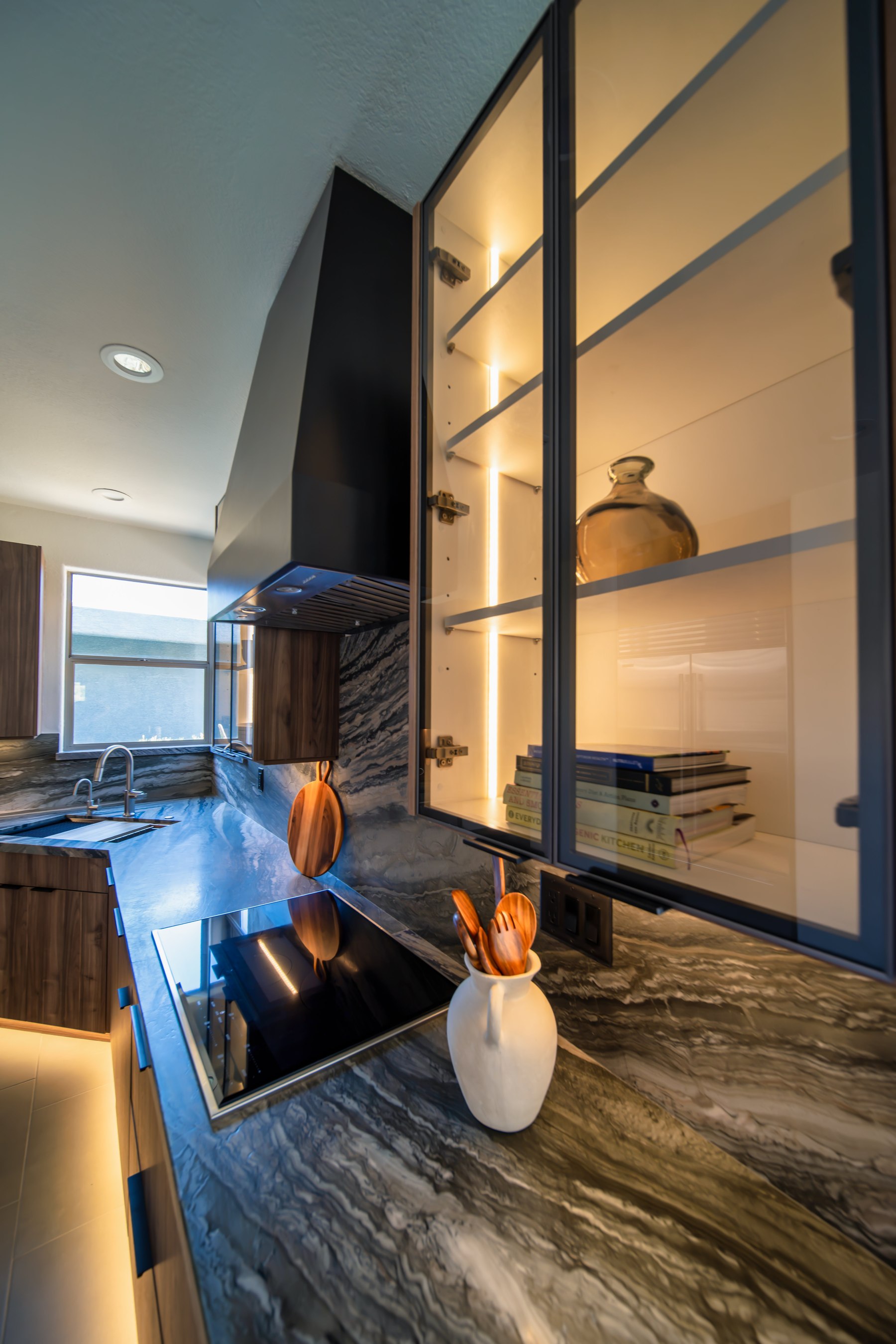 Finished glass-front cabinetry detail with induction cooktop, Fountain Hills remodel