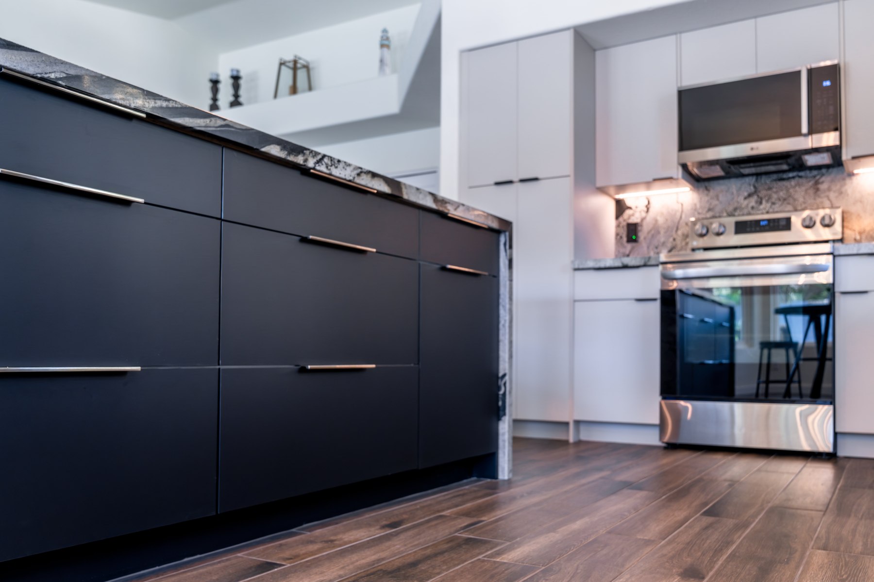 Custom navy island cabinetry and wood-look flooring in a finished Phoenix kitchen remodel