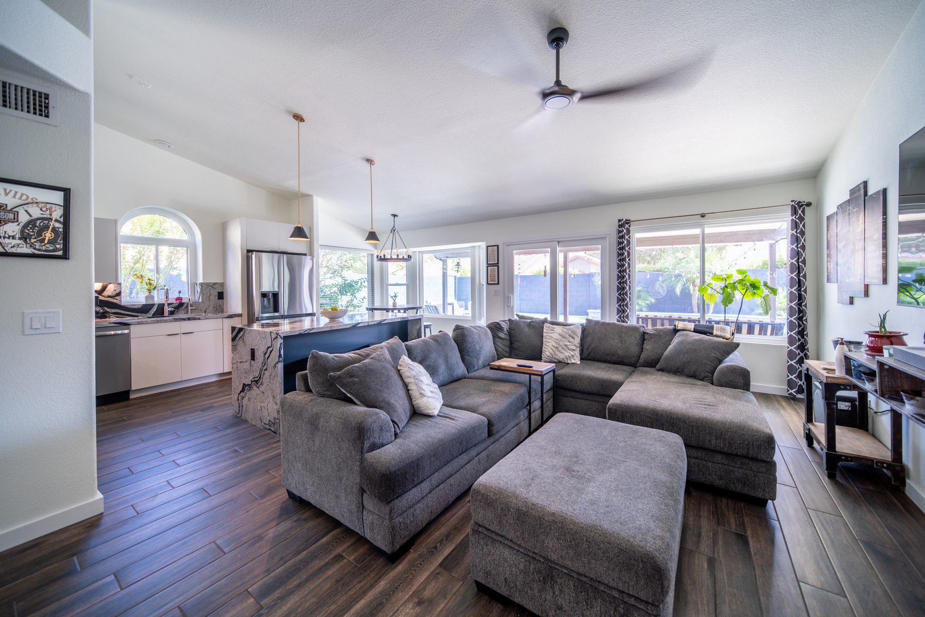 Finished living room and kitchen connected by matching wood-look flooring, Phoenix remodel