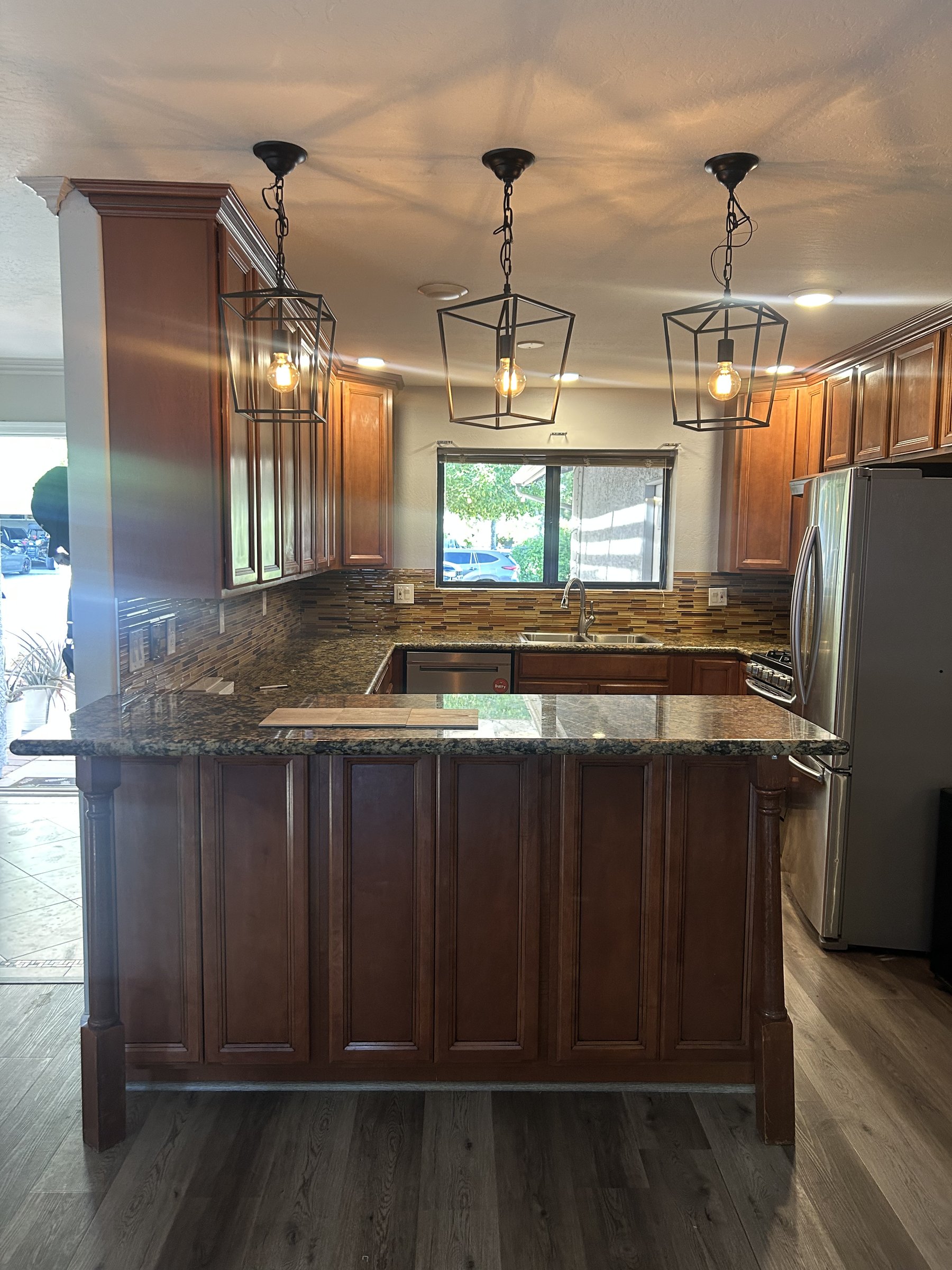 Original dark cherry cabinets and pendant lights before Phoenix remodel
