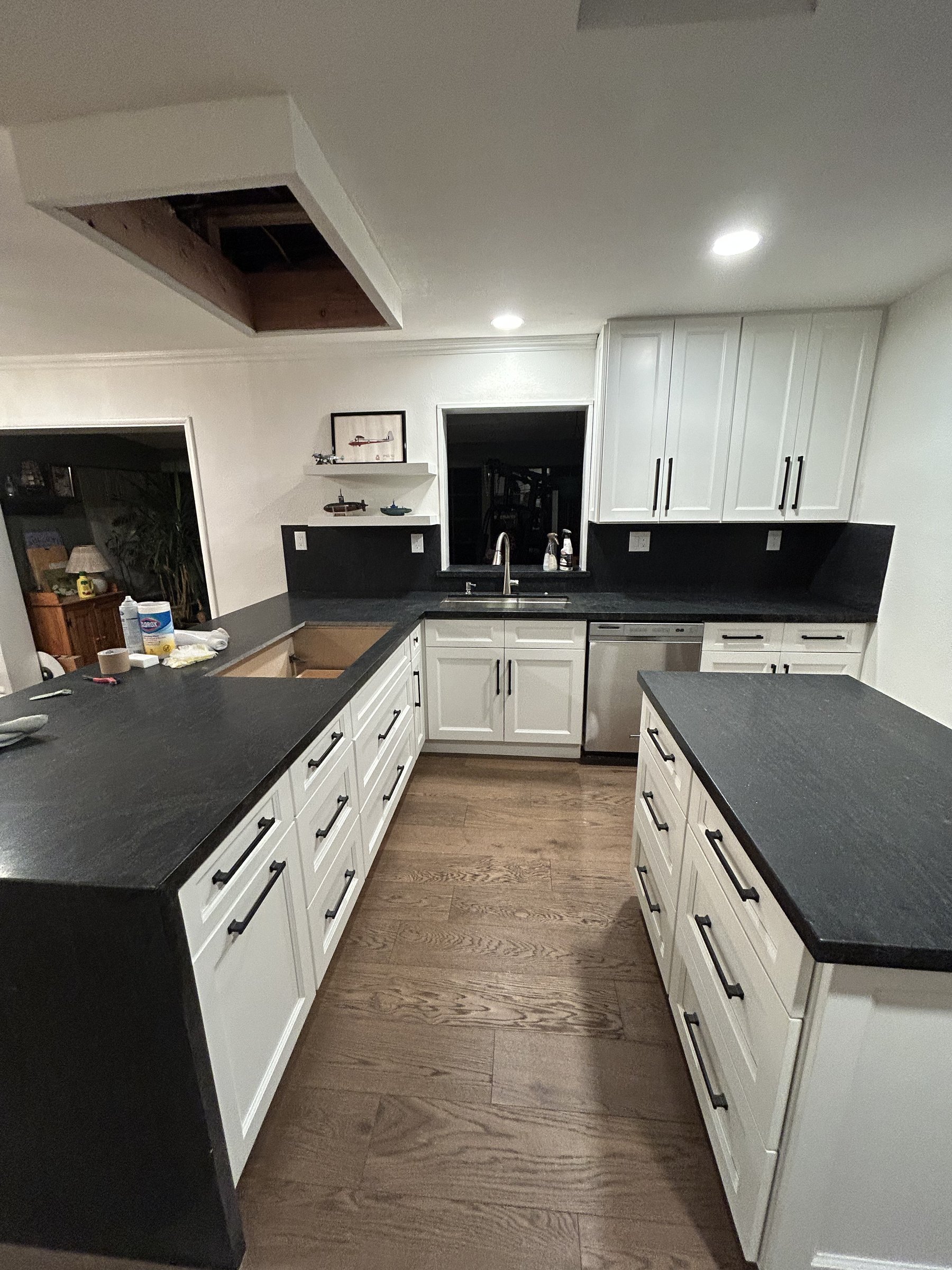 Near-finished kitchen with new hardwood flooring and black countertops installed, Scottsdale remodel